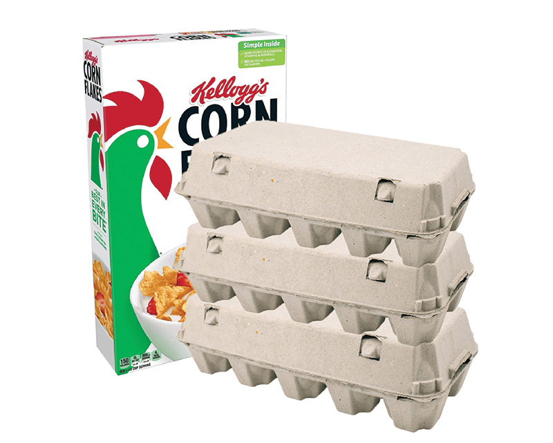 A box of Kellogg's Corn Flakes cereal is positioned next to three stacks of a dozen eggs, packaged in grey cardboard cartons. The Corn Flakes box features an illustration of a rooster