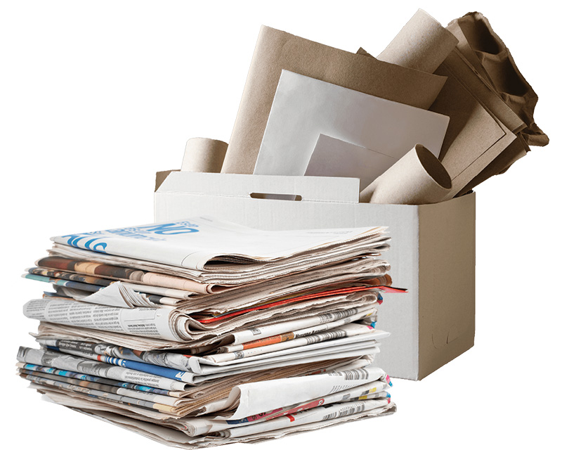 A stack of newspapers and other papers placed in front of a cardboard box filled with various types of papers and rolled-up sheets.