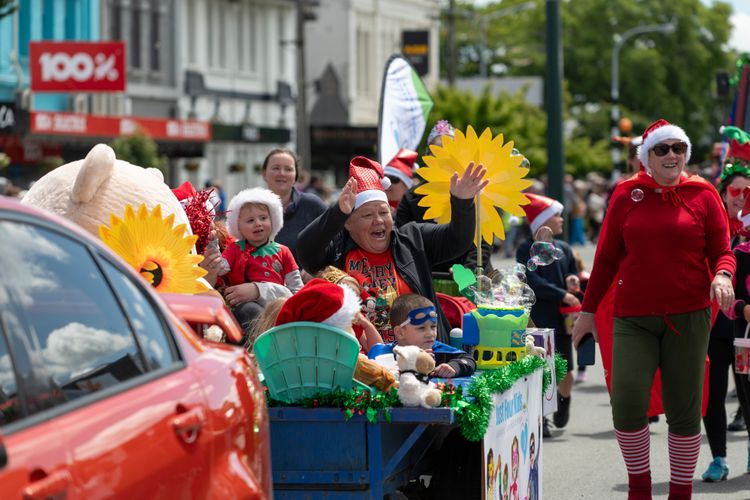 Lady waving with children sitting in float at the Gore Santa Parade 